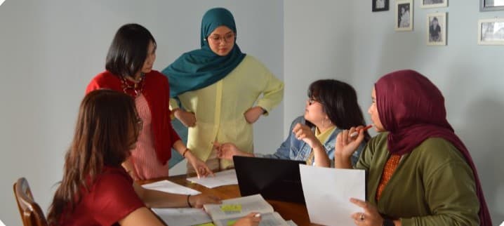 BOI Research team members discussing printed research material around a table