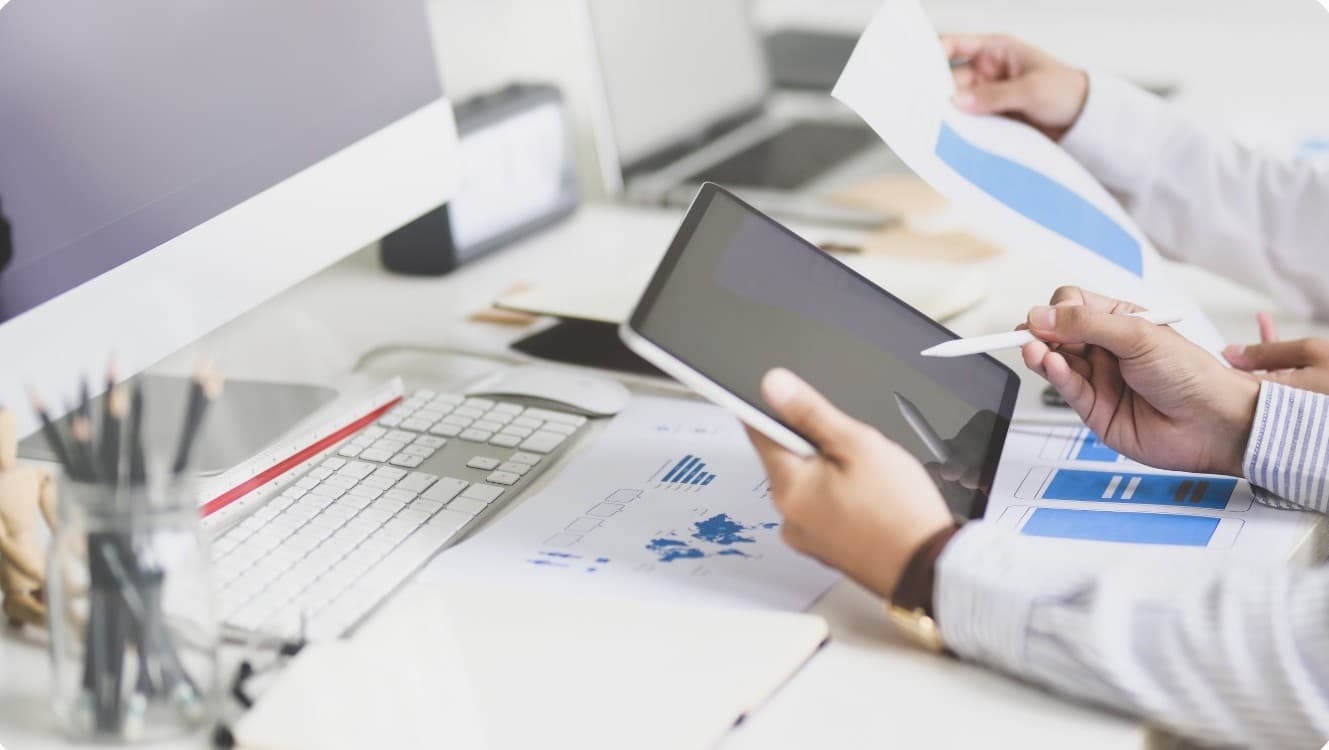 Researchers reviewing charts and survey results on a tablet